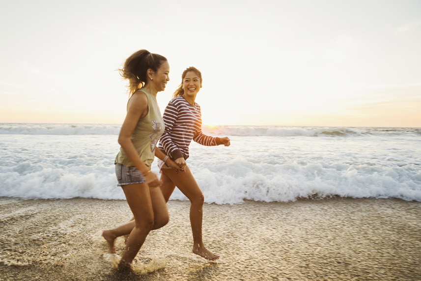 Two women running on the beach