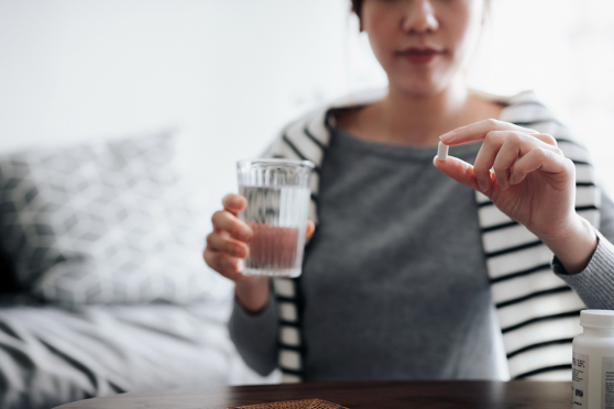 Woman with glass of water and diabetes medication